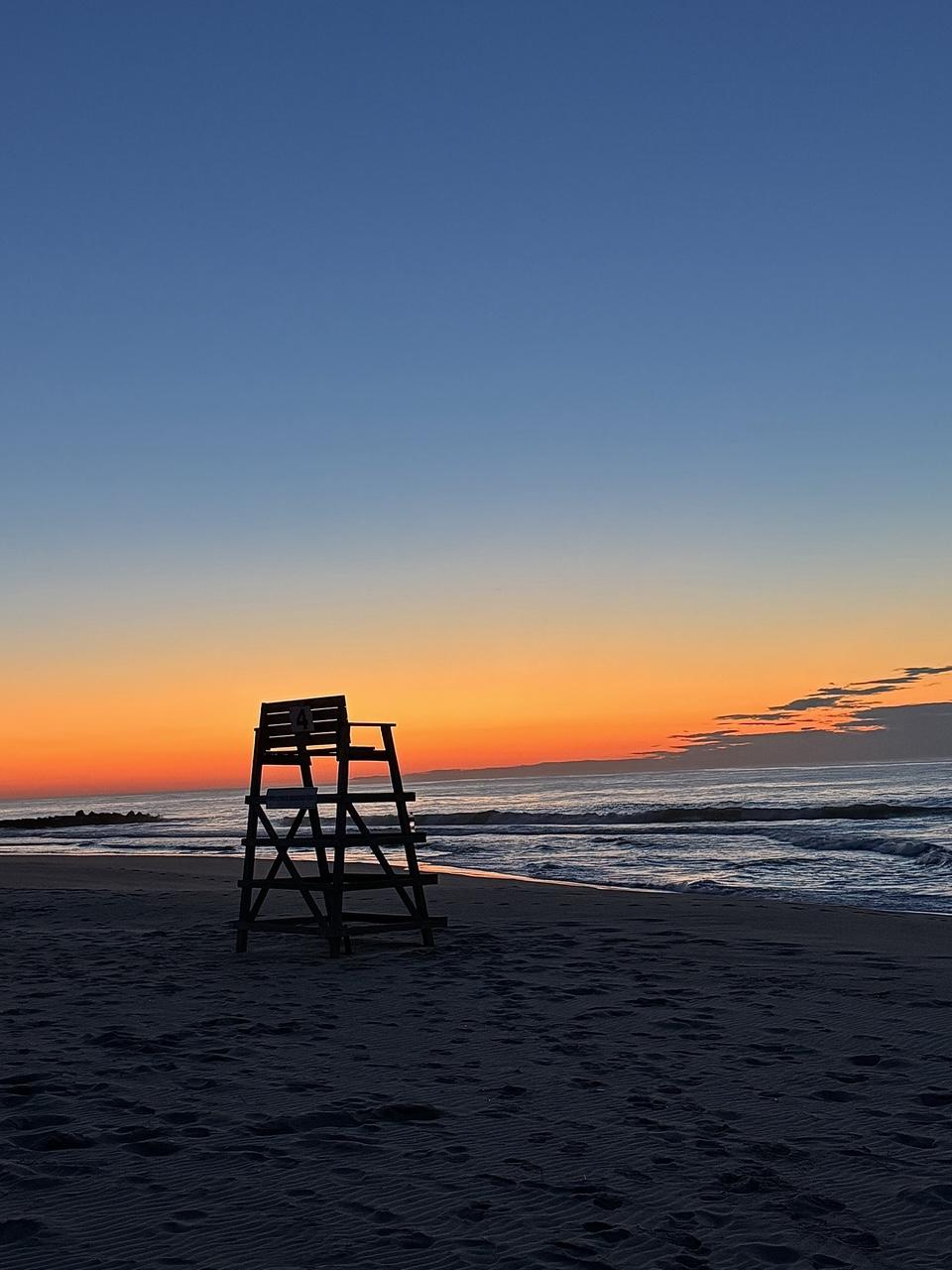 A silhouette of a beach chair at dawn